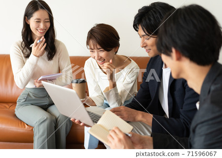四個年輕人和婦女坐在營業所的沙發上和開會 四個年輕人和婦女坐在營業所的沙發上和開會 71596067