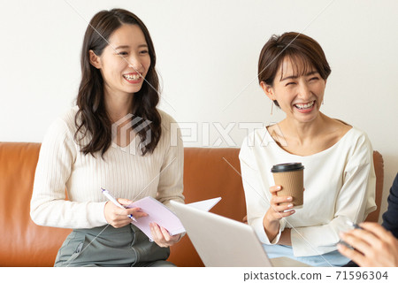 兩個年輕女子坐在商務辦公沙發上,開會 兩個年輕女子坐在商務辦公沙發上,開會 71596304