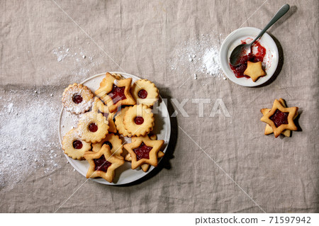 Linz shortbread biscuits cookies with jam on linen tablecloth. Flat lay 71597942