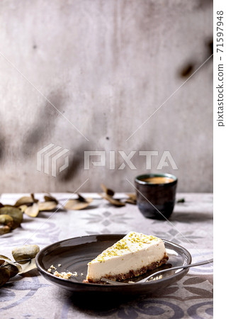 Raw vegan cheesecake with lime zest and cashew nuts on plate Raw vegan cheesecake with lime zest and cashew nuts on plate 71597948
