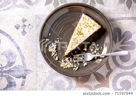 Raw vegan cheesecake with lime zest and cashew nuts on plate. Top view 71597949