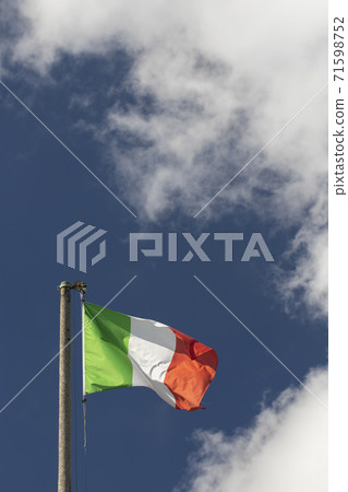Italian flag blowing in the wind in the blue sky 71598752