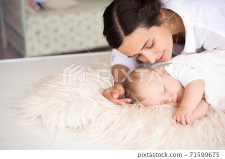 Young mother, holding tenderly her newborn baby boy Young mother, holding tenderly her newborn baby boy 71599675