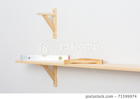 The process of attaching a wooden shelf to the wall 71599974