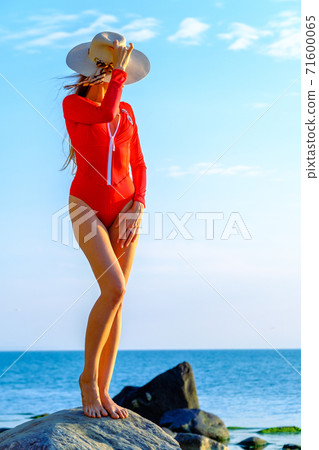 Slender woman in swimsuit at seaside in summer 71600065
