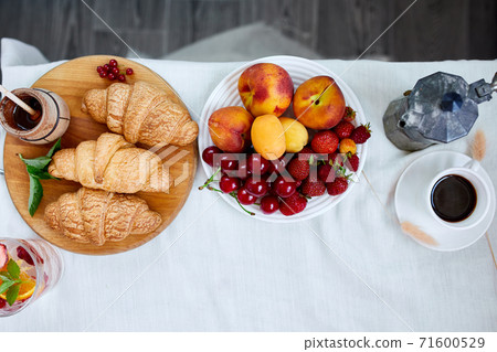 Two coffee cups and Italian coffee maker with croissant and fruits 71600529