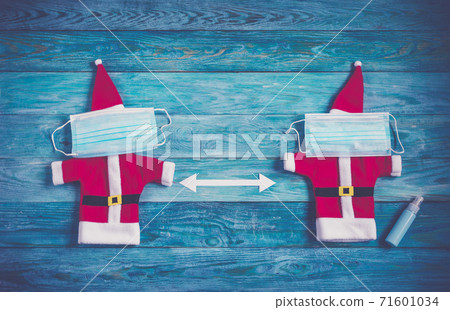 Santa clothes with a medical face mask on brown wooden background Santa clothes with a medical face mask on brown wooden background 71601034