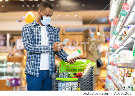 African American Man Using Mobile Phone Scanning Product In Supermarket African American Man Using Mobile Phone Scanning Product In Supermarket 71601202