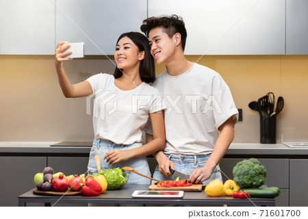 Happy Asian Couple Making Selfie Cooking In Kitchen At Home Happy Asian Couple Making Selfie Cooking In Kitchen At Home 71601700