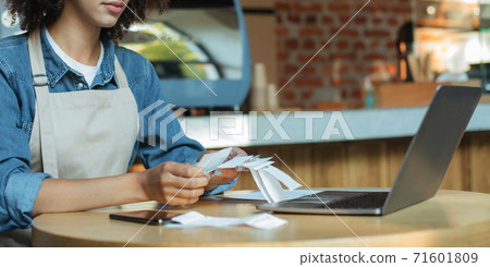 Millennial african american woman owner manager in apron works with account and bookkeeping in cafe, panorama, cropped 71601809