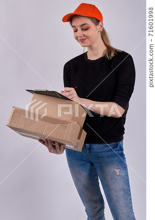 Smiling female courier is signing documents. 71601998