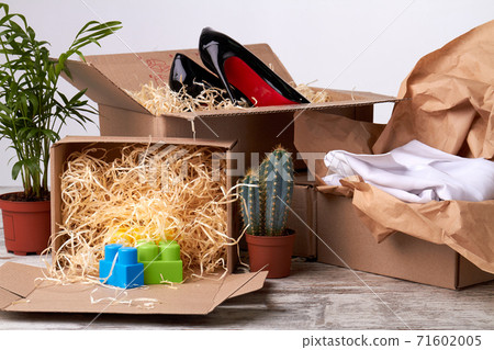 Unpacked boxes with shoes, clothes and toys. Unpacked boxes with shoes, clothes and toys. 71602005