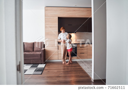 Mother cuddling with daughter 71602511