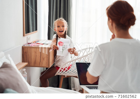 Daughter showing to her mom new drawing 71602562