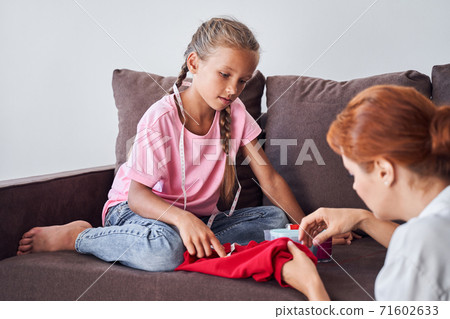 Girl learning how to sew 71602633