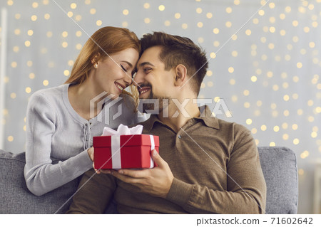 Happy young couple touching noses tenderly after exchanging presents on Valentine's Day 71602642