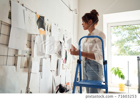 Girl standing on a stepladder Girl standing on a stepladder 71603253