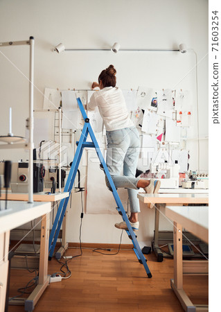 Designer hanging her sketches Designer hanging her sketches 71603254
