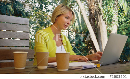 workaholic woman working on laptop in cafe outdoors with three cups of coffee 71603301