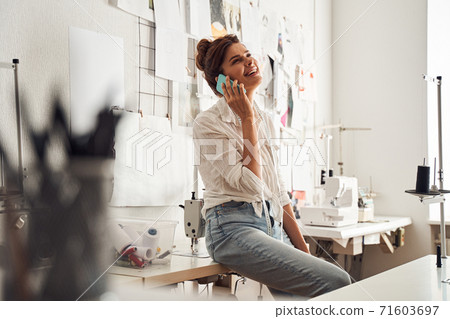 Designer using smartphone while sitting Designer using smartphone while sitting 71603697