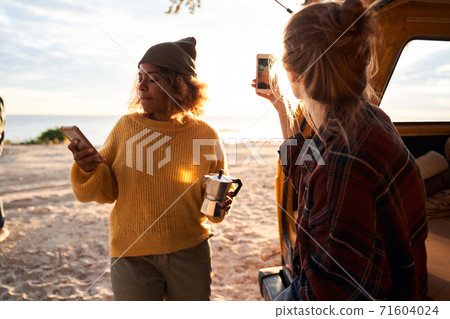 Girls using smartphones at the nature Girls using smartphones at the nature 71604024