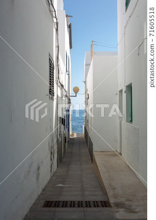 The passage to the ocean between the houses in the city in Arrieta on the island of Lanzarote. 71605518