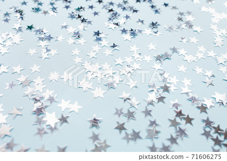 Silver foil confetti stars on blue background Silver foil confetti stars on blue background 71606275