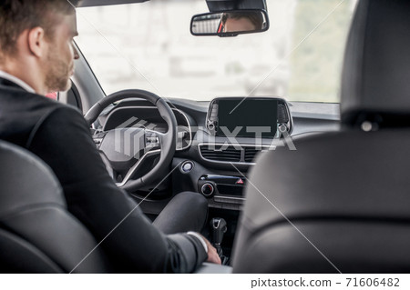 Rear view of male sitting at driver's seat 71606482