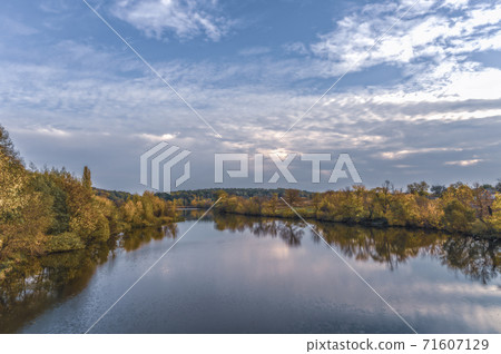View of the bed of the Rostavitsya river with the banks overgrown with autumn forest. Ukraine 71607129