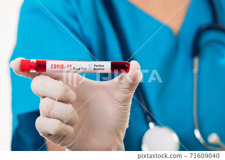 Nurse in blue uniform wear a mask holding test tube sample Coronavirus test blood Nurse in blue uniform wear a mask holding test tube sample Coronavirus test blood 71609040