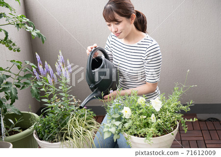 一個女人享受園藝和小組種植在陽台上 一個女人享受園藝和小組種植在陽台上 71612009