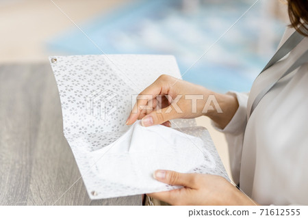 A woman's hand to put the mask in use in the mask case A woman's hand to put the mask in use in the mask case 71612555