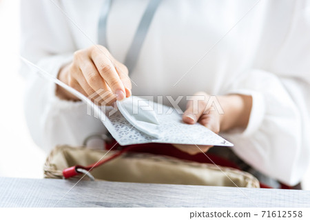 A woman's hand to put the mask in use in the mask case A woman's hand to put the mask in use in the mask case 71612558