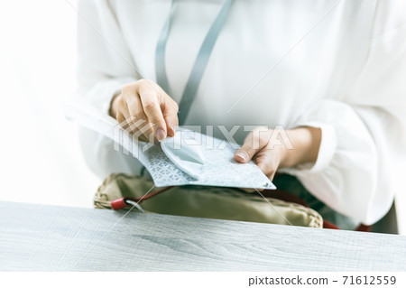 A woman's hand to put the mask in use in the mask case A woman's hand to put the mask in use in the mask case 71612559