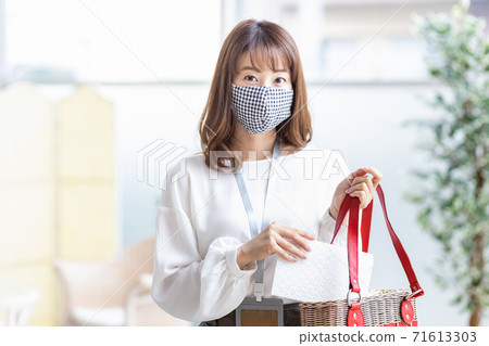 A woman who puts a mask case in her bag when going out A woman who puts a mask case in her bag when going out 71613303