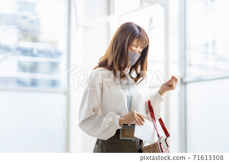 A woman who puts a mask case in her bag when going out 71613308