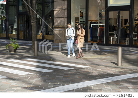 Japanese women who give directions to foreign women and cross the pedestrian crossing together Japanese women who give directions to foreign women and cross the pedestrian crossing together 71614823
