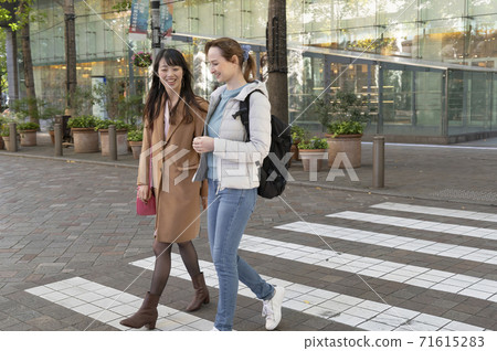 日本婦女和外國婦女邊聊天邊過人行橫道 日本婦女和外國婦女邊聊天邊過人行橫道 71615283