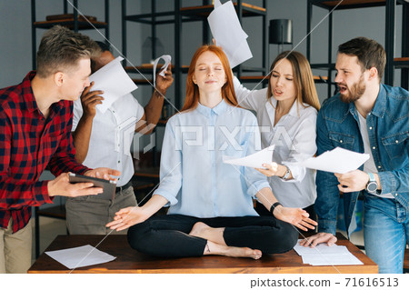 Portrait of calm young woman meditate at meeting avoiding pressure annoying angry colleagues Portrait of calm young woman meditate at meeting avoiding pressure annoying angry colleagues 71616513