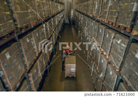 Top view of people standing in megastore with lots of containers on the shelves 71621000