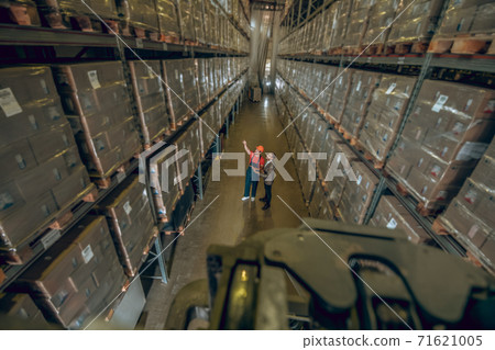 Two people in megastore with lots of containers on the shelves 71621005