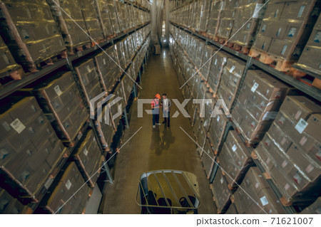 Top view of two people in megastore with lots of containers on the shelves 71621007