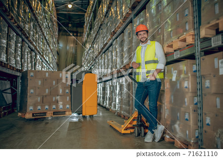 Young male worker standing near shelves and looking determined 71621110