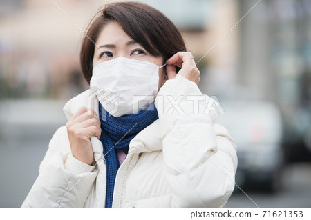 A winter woman wearing a mask, down coat and winter clothes A winter woman wearing a mask, down coat and winter clothes 71621353