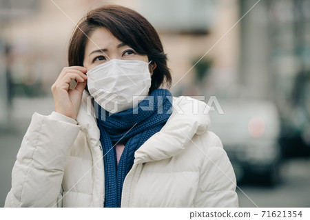 A winter woman wearing a mask, down coat and winter clothes 71621354