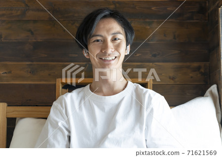 一個年輕人戴著耳機,看著相機 一個年輕人戴著耳機,看著相機 71621569