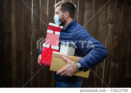 man holding pile of Christmas gift boxes man holding pile of Christmas gift boxes 71622799