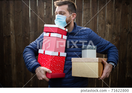 man holding pile of Christmas gift boxes man holding pile of Christmas gift boxes 71622800