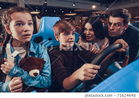 Mom and Dad suggest son how to play a video game. Mom and Dad suggest son how to play a video game. 71624648