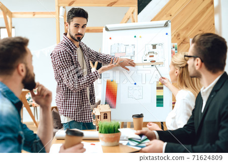 People sit at table and listen to presentation. 71624809